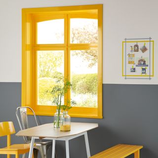 bright yellow painted timber window frame in a grey dining room
