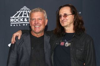 A picture of Alex Lifeson and Geddy Lee posing for photographers