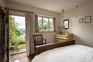 bedroom with open door in renovated rustic cottage