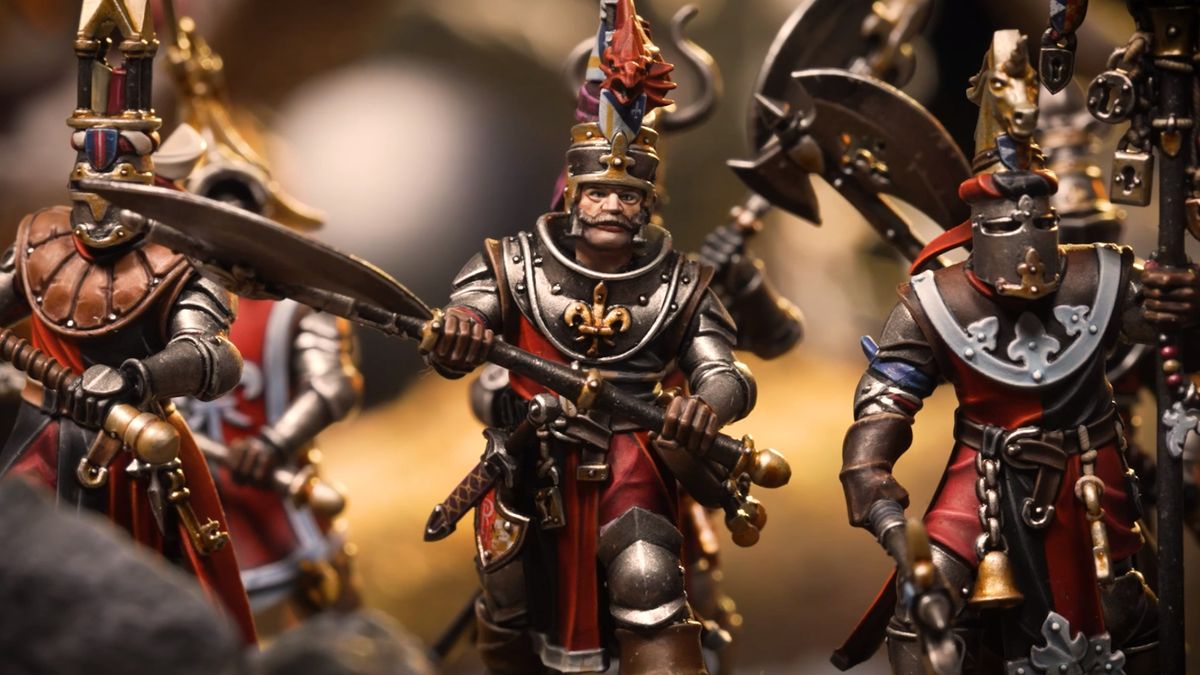 A unit of Bretonnian Knights of the Realm on foot march forward with greataxes in hand