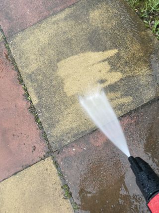 cleaning a patio using a pressure washer