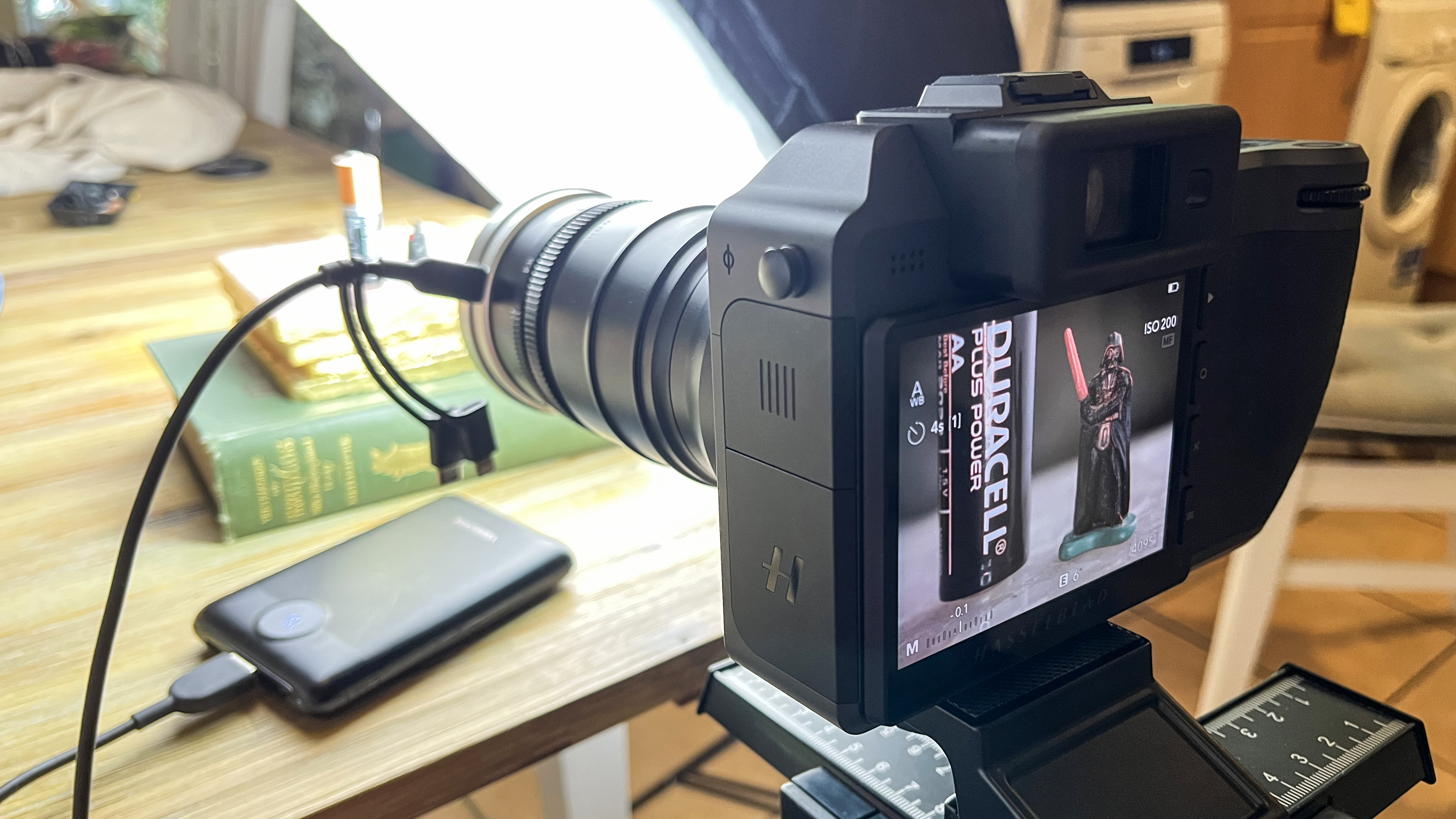 Mitakon 55mm f/2.8 1-5x Macro lens on a Hasselblad camera, taking a shot of a miniature Darth Vader and a battery