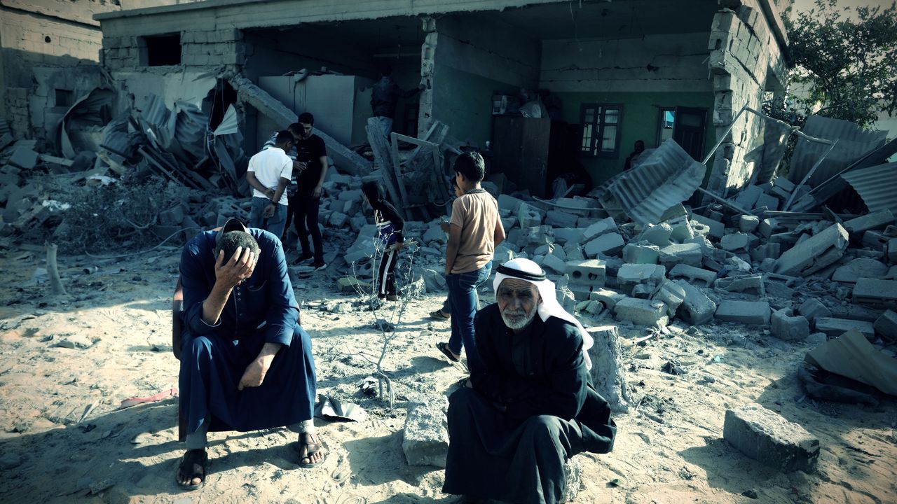 People check for usable items from building in Rafah bombed by Israel