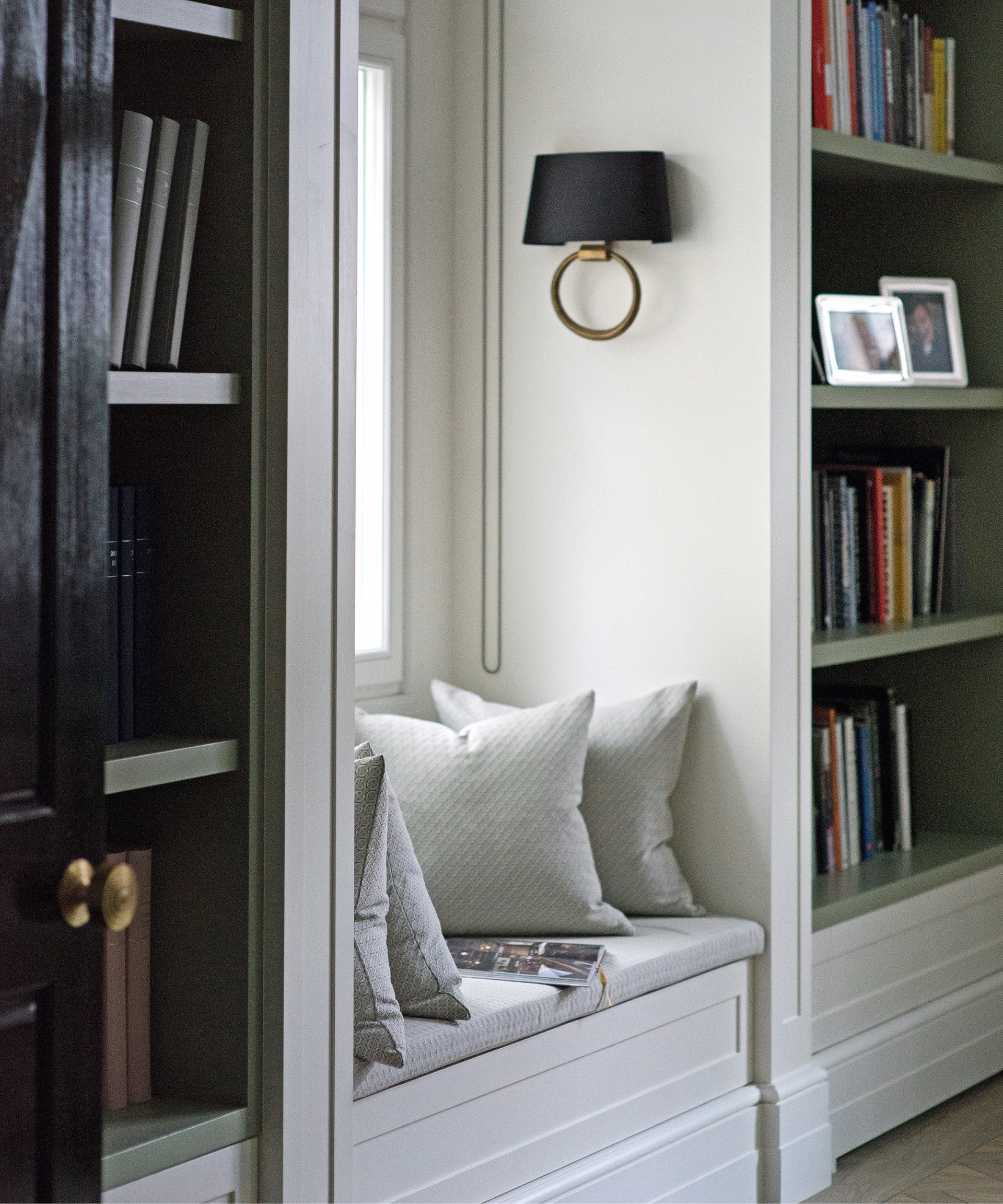 inbuilt window seat in neutral colors in between two inbuilt bookshelves