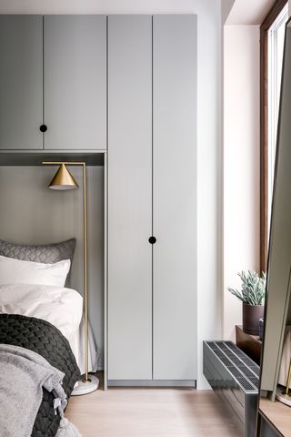Mono stockholm bedroom with white and grey bedding and a bronze floor lamp