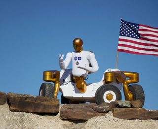 NASA's Robonaut 2 strikes a post atop its new wheeled base, Centaur 2, at the Johnson Space Center Planetary Analog Test Site in Houston. The Centaur base builds off of lessons learned through the Space Exploration Vehicle, a rover for astronauts, and could allow the dexterous humanoid robot to help with the future exploration of distant planetary surfaces.