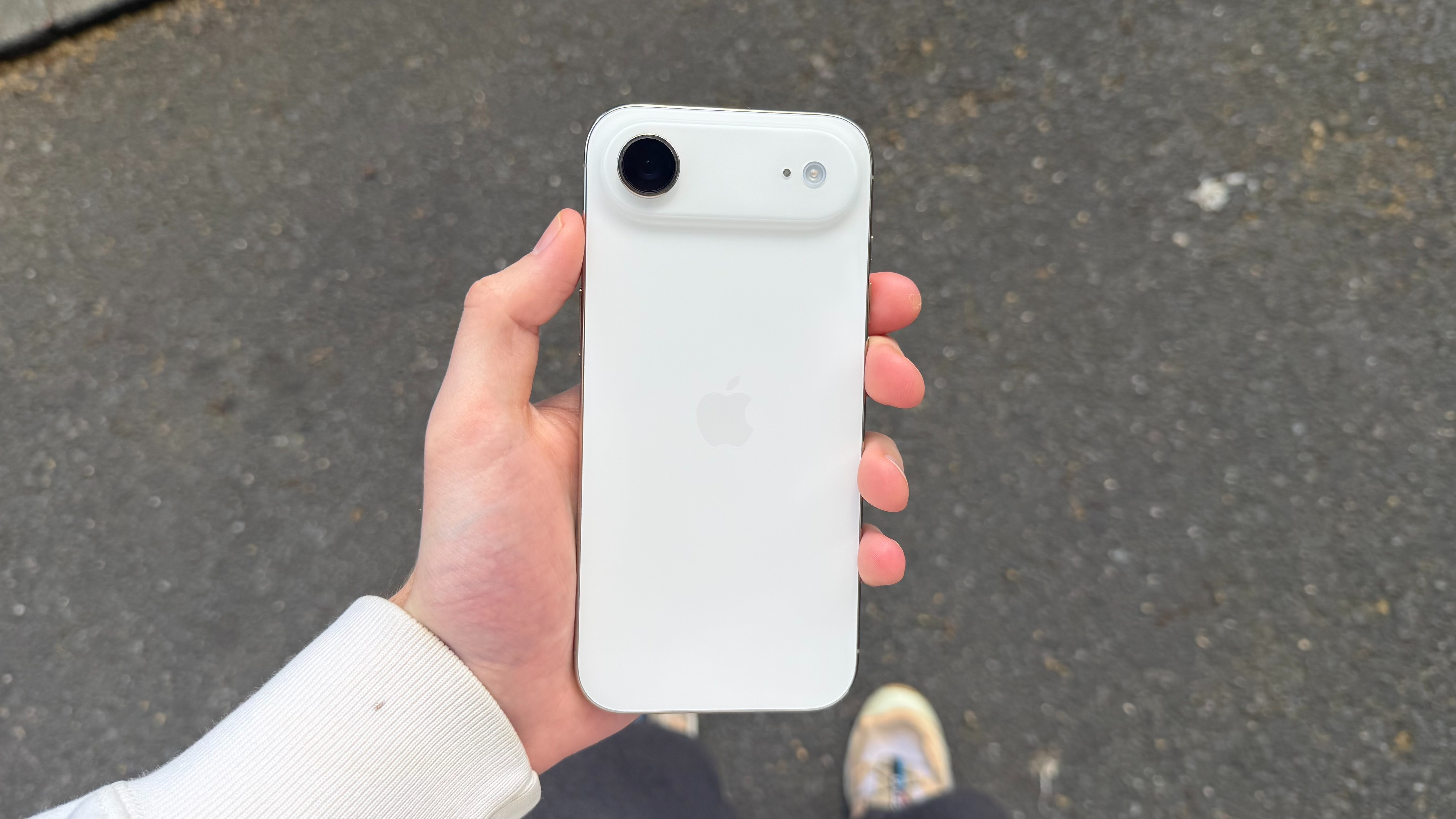 The iPhone Air being held in the hand outside