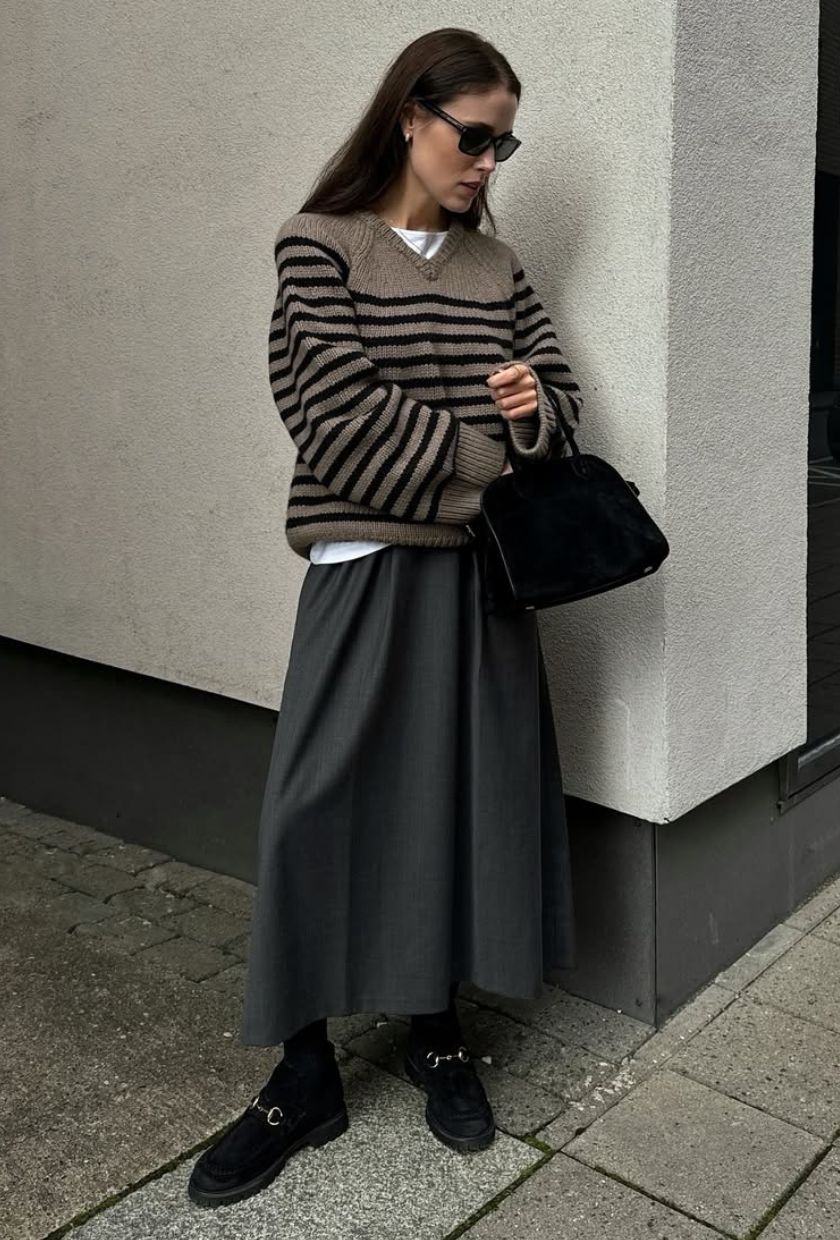 @annabelrosendahl wears a grey and black striped jumper, grey midi skirt, black loafers and sunglasses