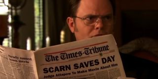 Dwight holding a newspaper that says Judge Attapow To Make Movie About Him in Threat Level Midnight