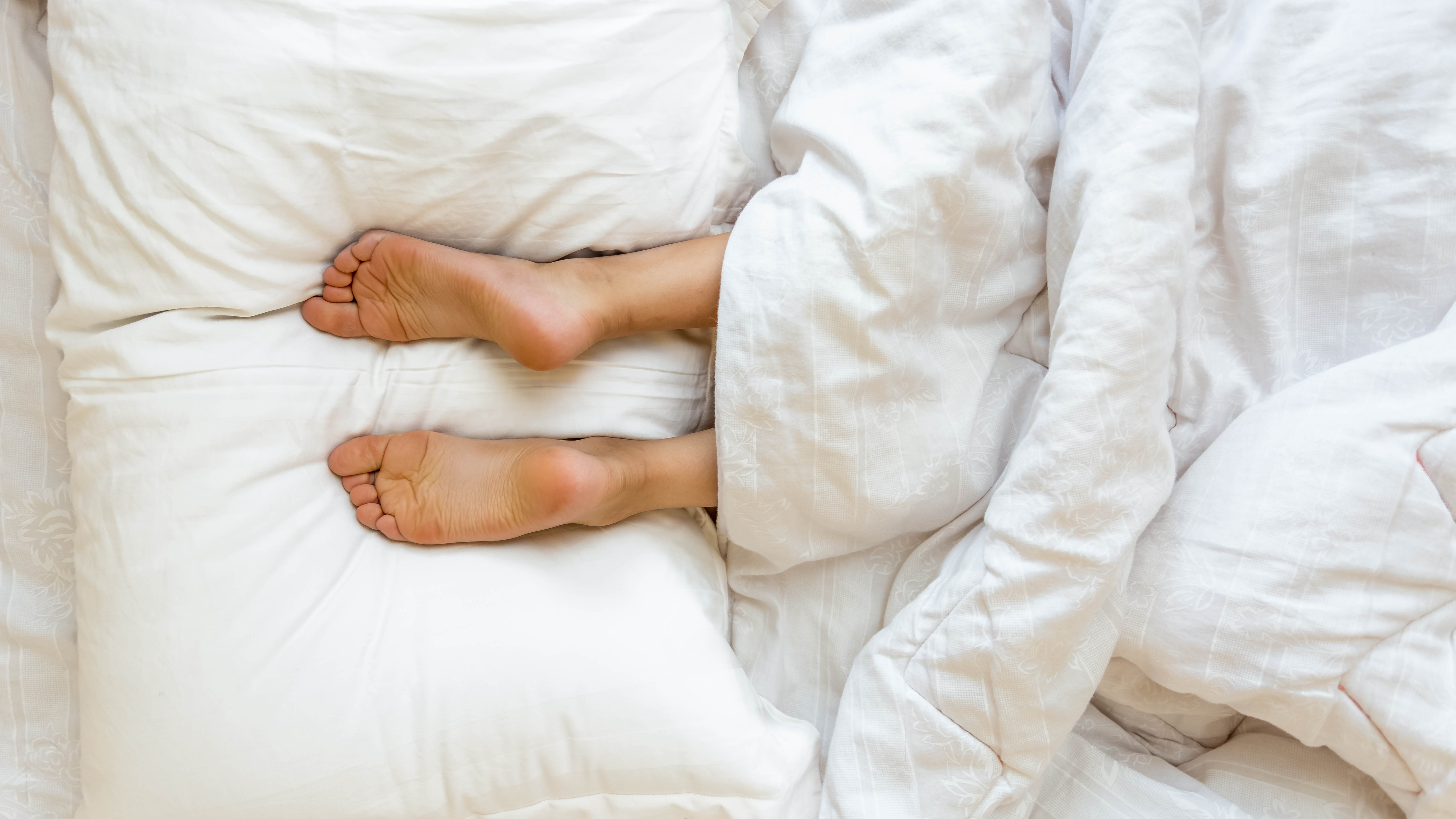 Feet on a set of pillows in bed