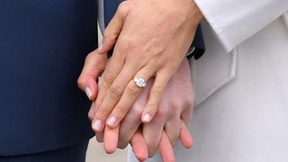 Prince Harry and Meghan Markle wearing her engagement ring holding hands