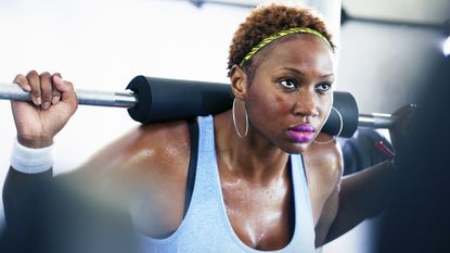 Mind-muscle connection: Pictured here, a sports woman lifting weights at the gym