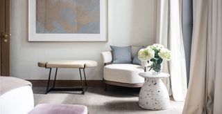 neutral living space with curved sofa design and stone side table to demonstrate key interior design trends 2023