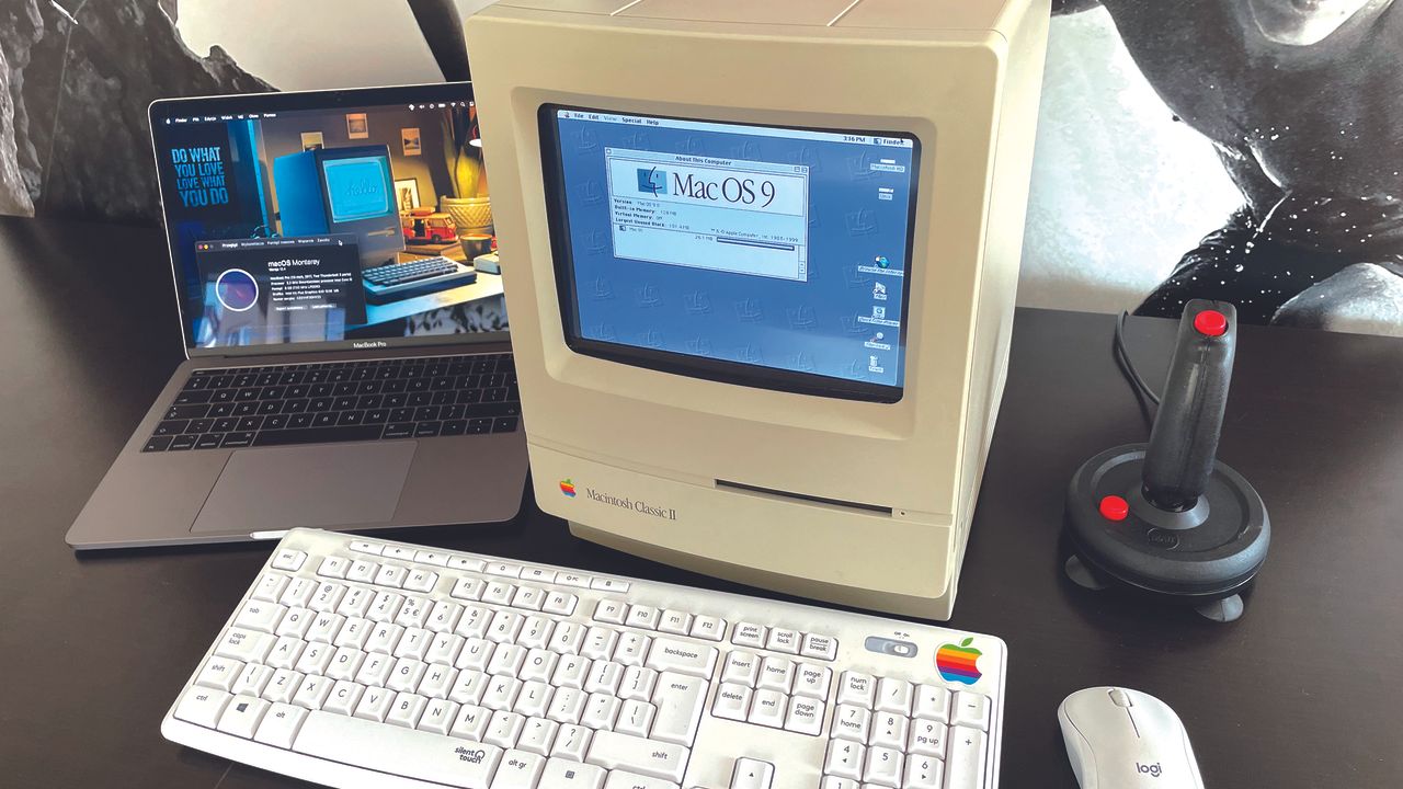 MacintoshPi running MacOS 9 in an Apple II Classic case sitting on a desk, with a keyboard, mouse, joystick, and MacBook Pro