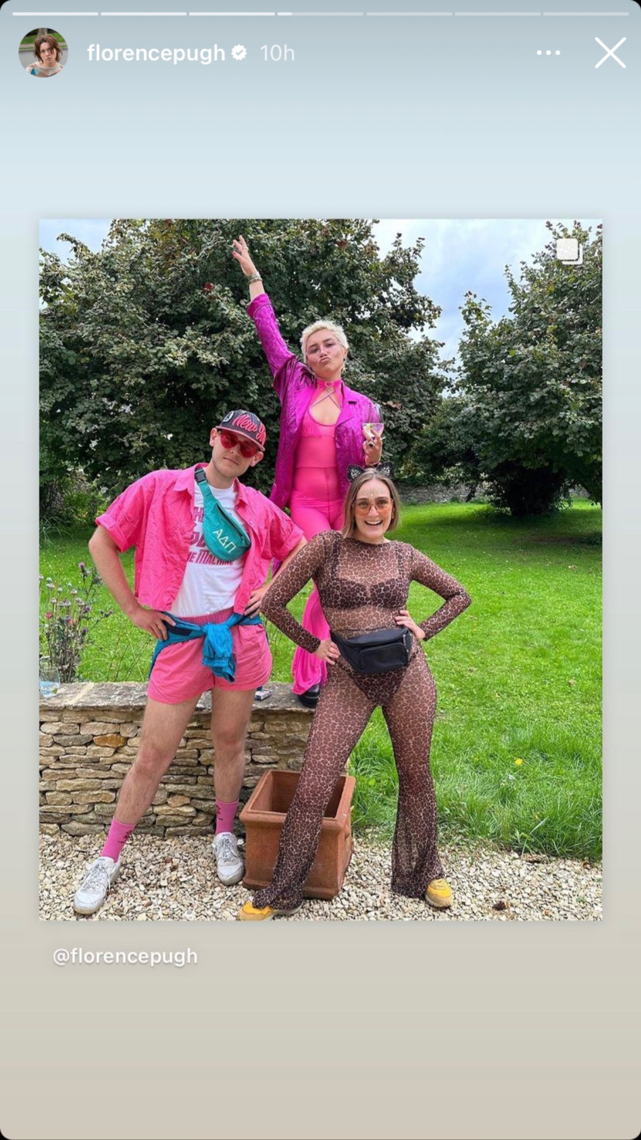 Florence Pugh wearing Barbie pink at a Music festival posing with friends.