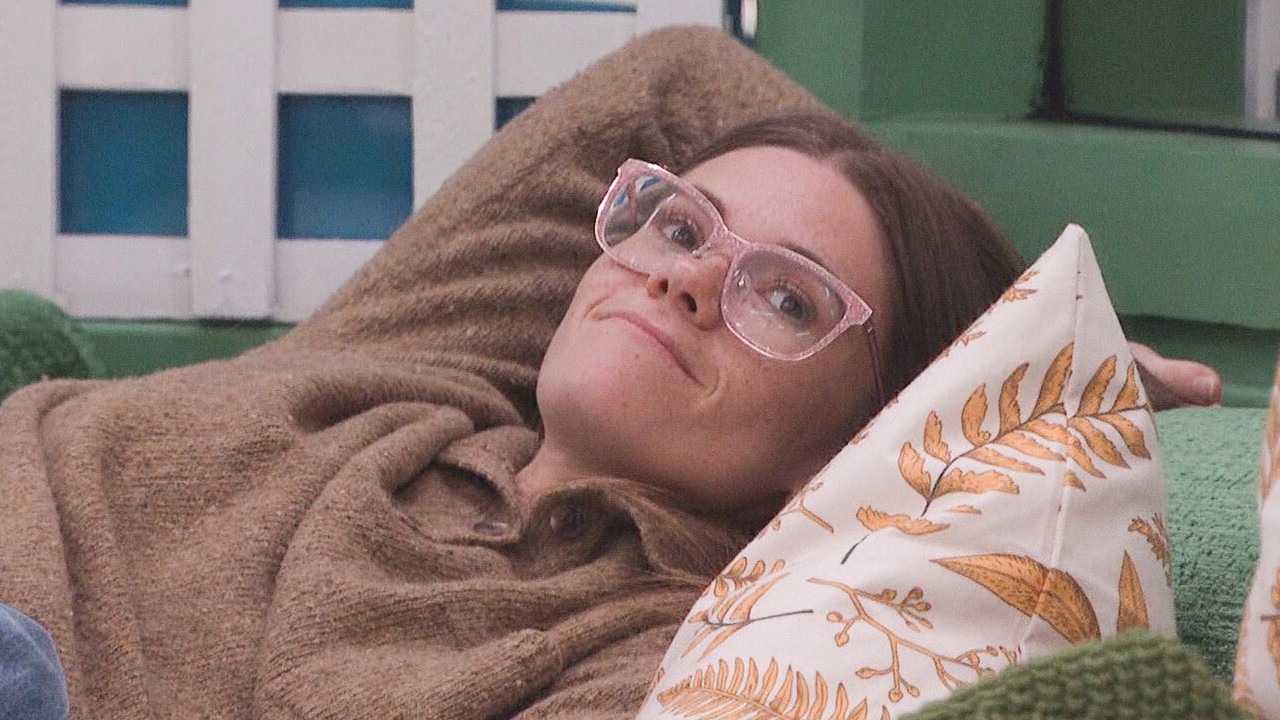Kelley sitting on a bed smiling