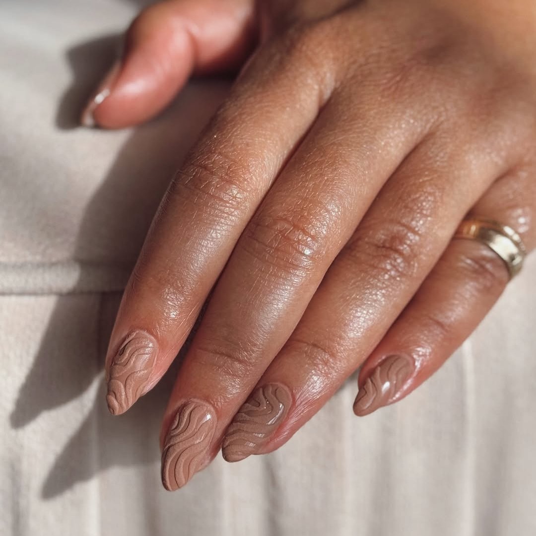 A mocha-colored textured nude manicure.