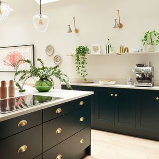 Black shaker kitchen with brass handles and white worktops