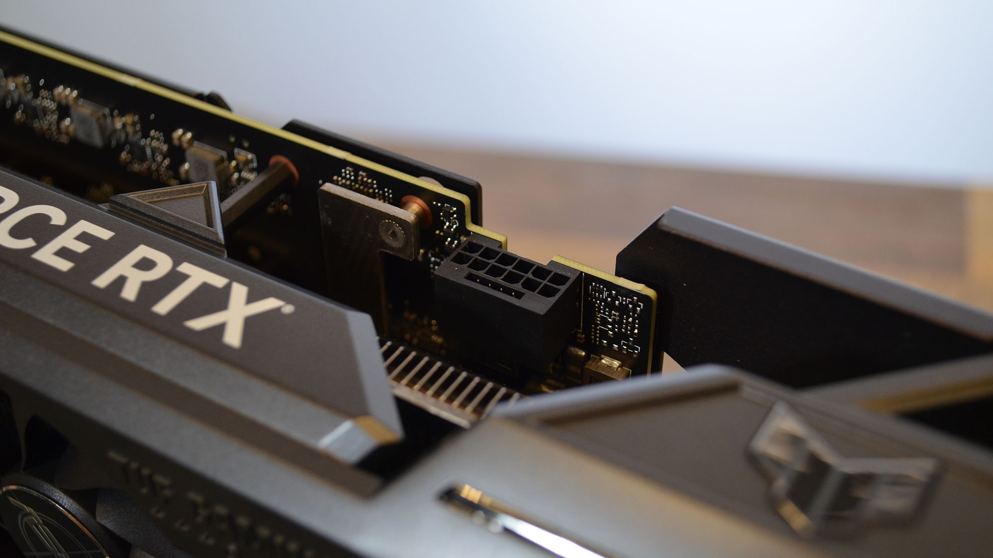 An Nvidia GeForce RTX 4070 Ti graphics card on a wooden table with its retail packaging