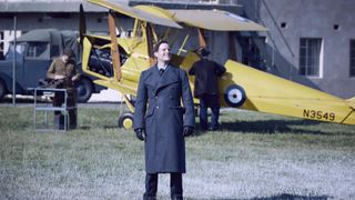 Nicholas Ralph in RAF uniform as James stands in front of a plane in All Creatures Great and Small.