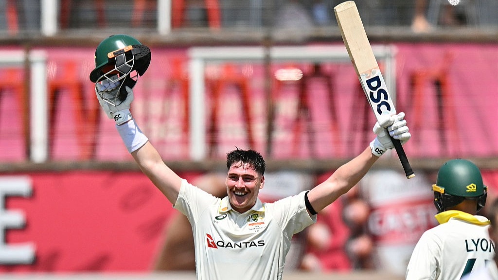 Matt Renshaw raises his bat and arms to celebrate scoring a Test century for Australia