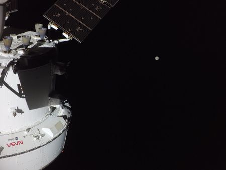 The Artemis II crew is en route to the Moon on the second flight day of the mission. This photo shows the Orion spacecraft with the Moon in the distance, as captured by a camera on the tip of one of its solar array wings.