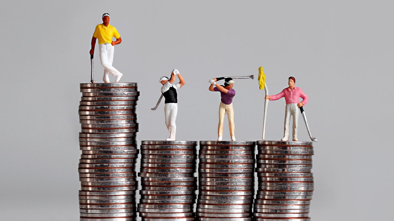 miniature figures of golfers on a pile of coins