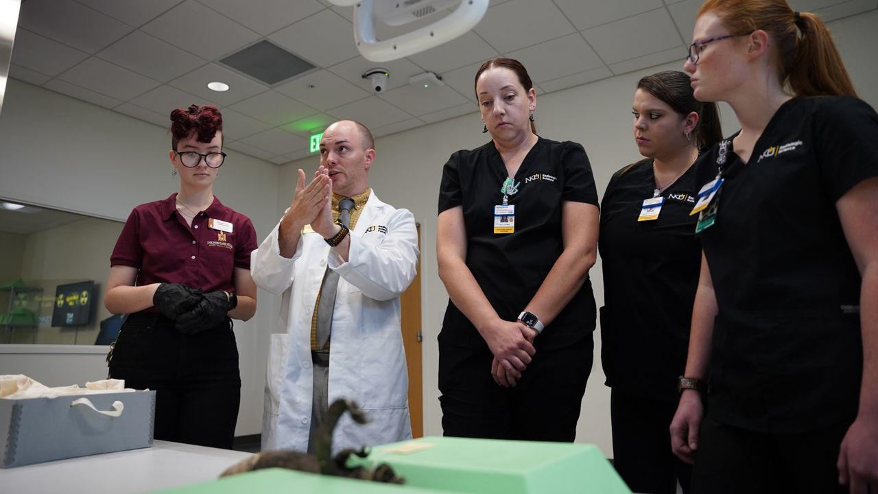 Scientists stand around the mermaid
