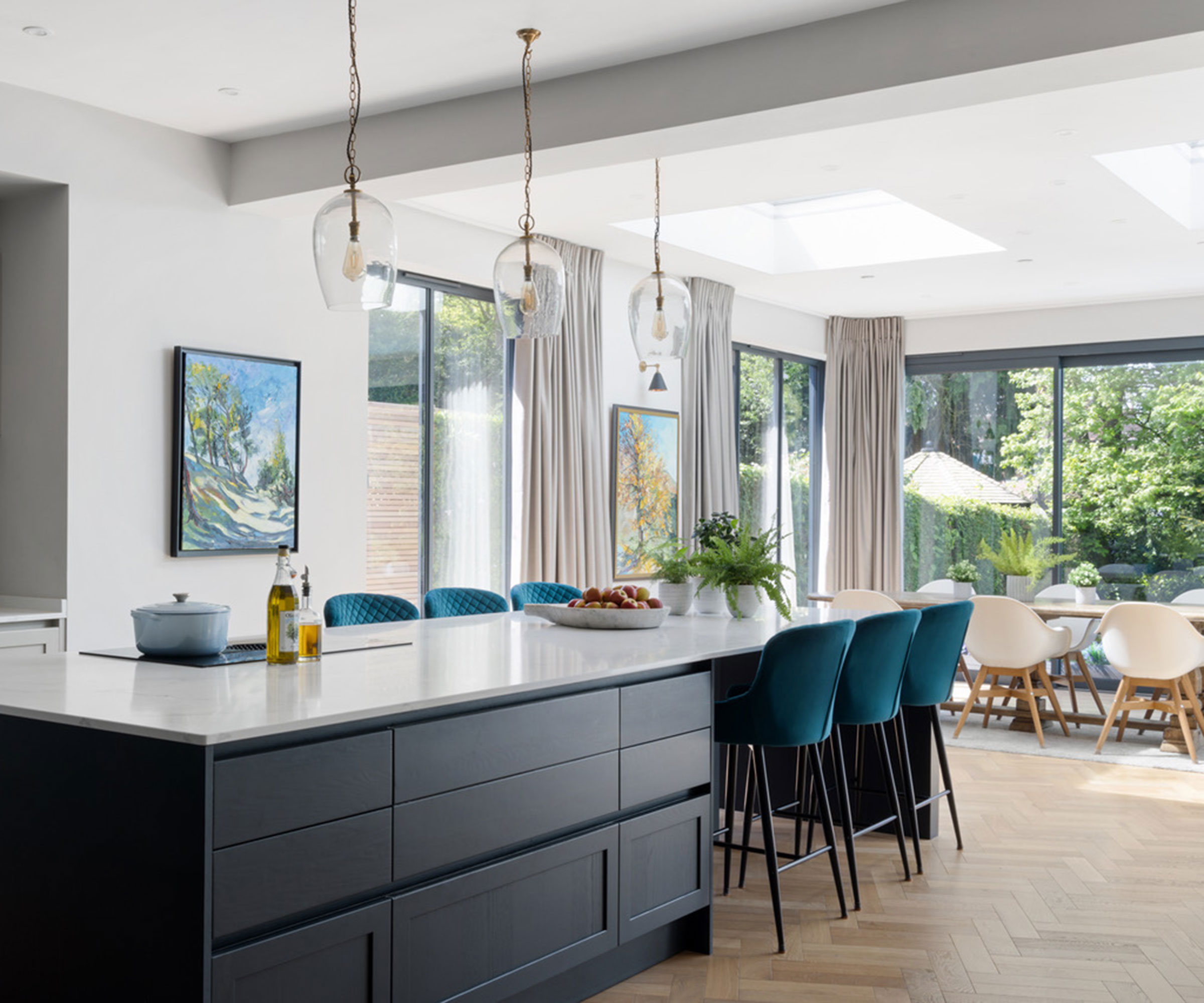 large open plan kitchen diner with large kitchen island with blue velvet bar stools