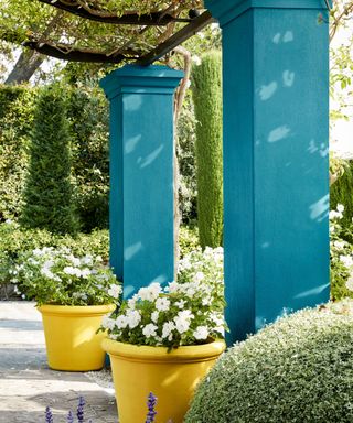 Garden columns painted turquoise with bright yellow pots