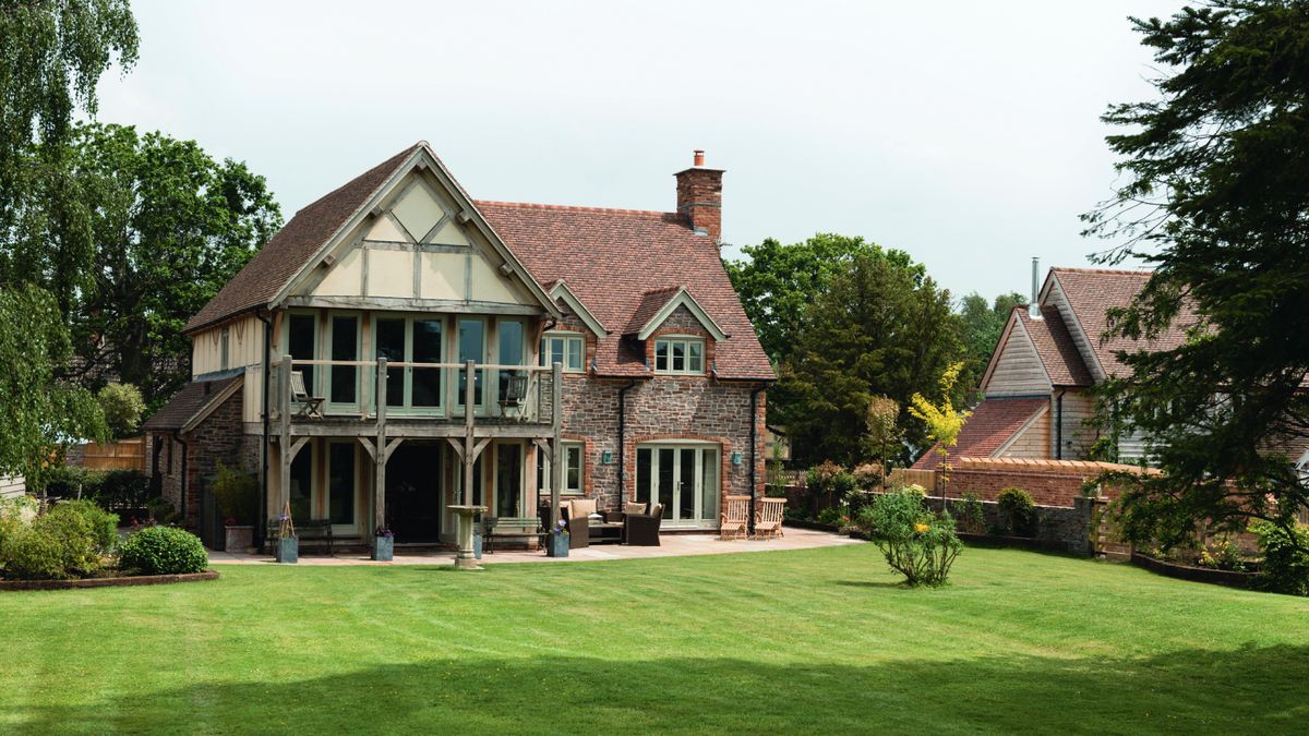 large country period property with tiled roof, brick walls, balcony and large grass lawn