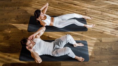 Pair performing crunches at home