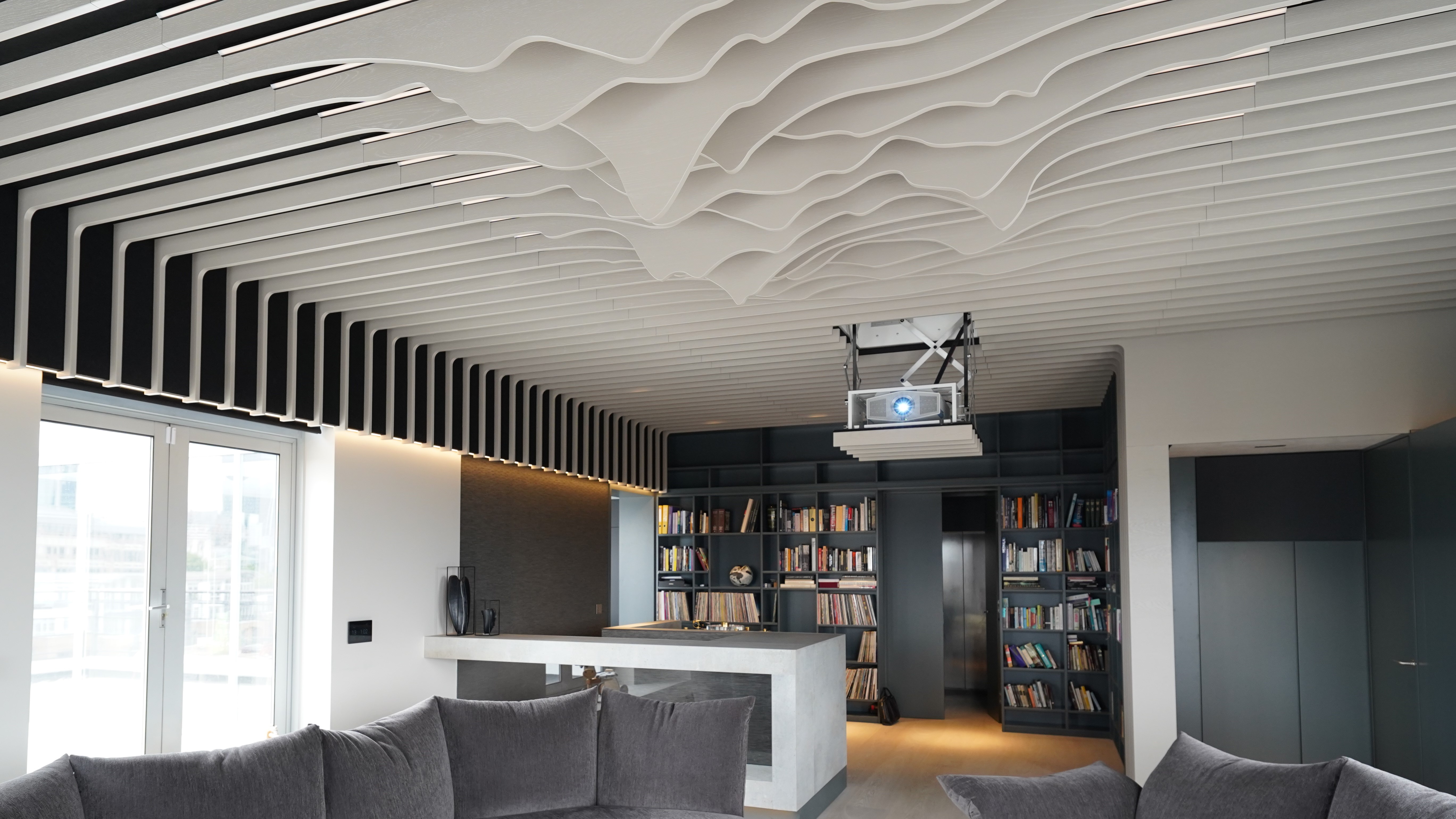 Home theater space with projector and sculptural elements on ceiling