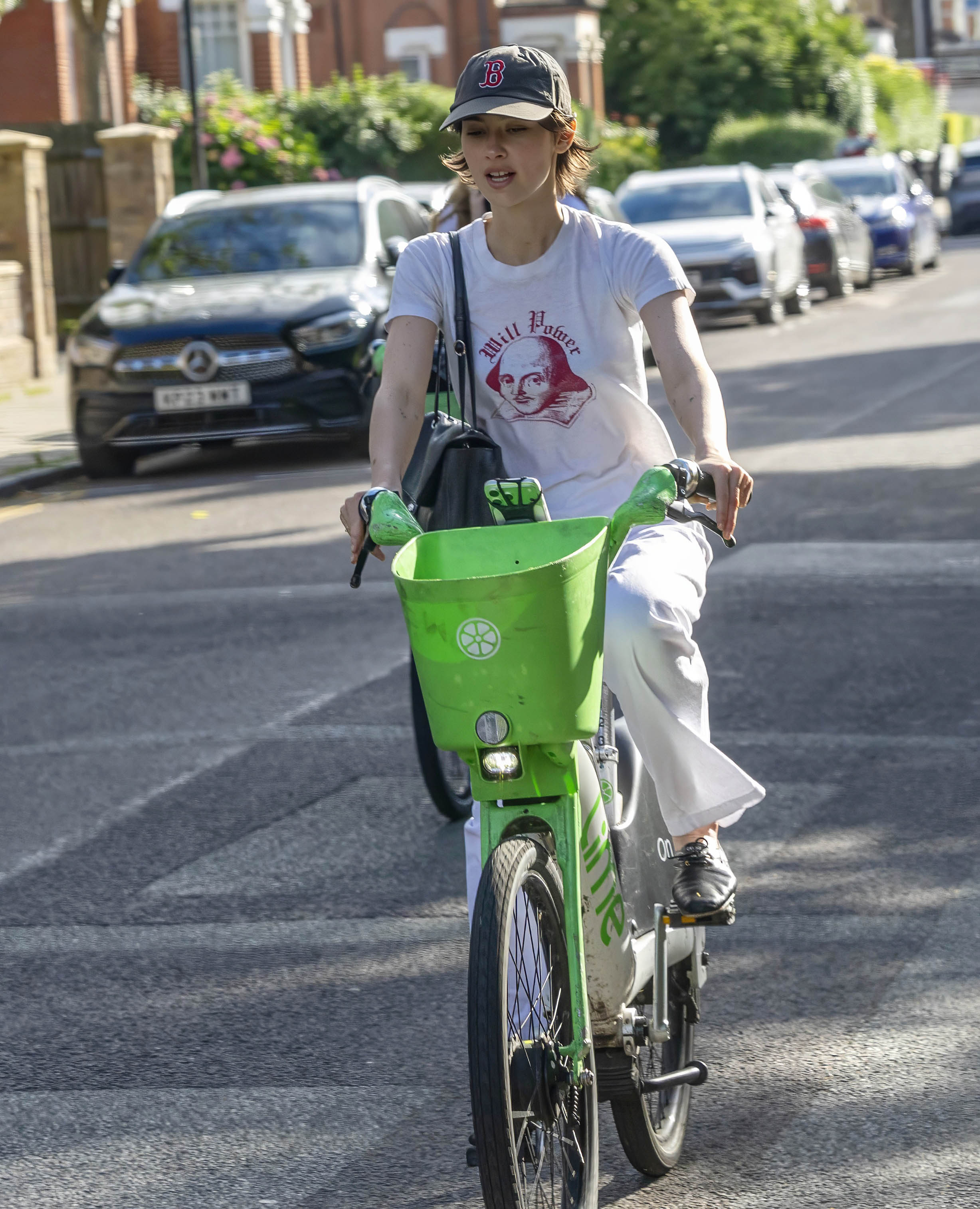 Gracie Abrams styled a white T-shirt, matching jeans, and the jazz shoe trend while riding a bike