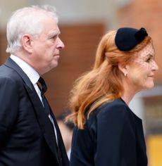 Prince Andrew walking behind Sarah Ferguson wearing black outfits