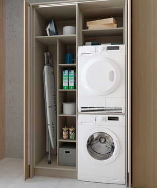 a utility space with stacked washer dryer and shelving with a pocket sliding door