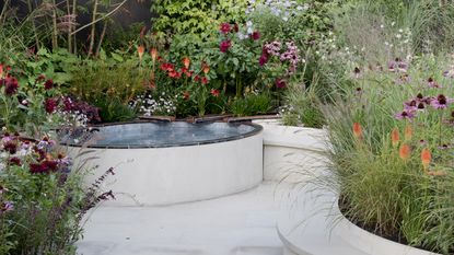 A curved light colored patio area with water feature