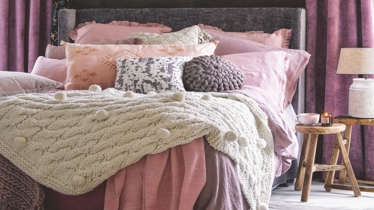 bedroom with piles of bedding and cushions