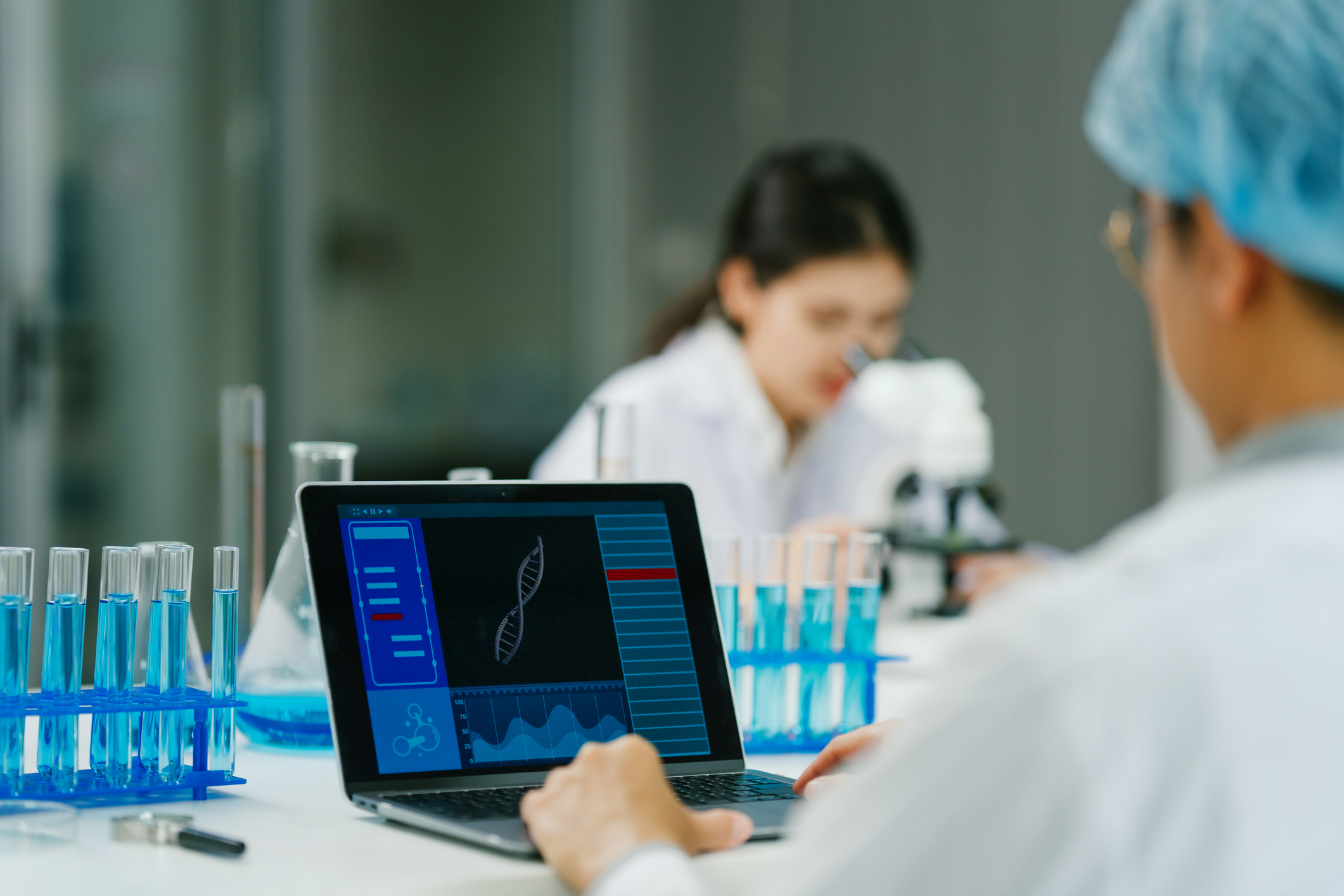 Professional scientist using laptop for genetic research in biotech lab