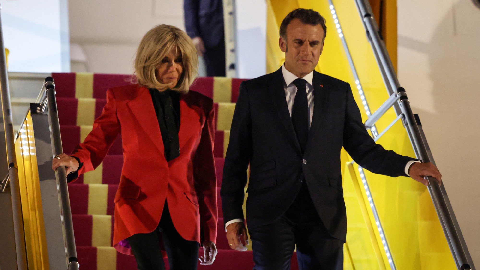 Emmanuel Macron and his wife Brigitte Macron disembark from the plane upon their arrival at Noi Bai International Airport in Hanoi