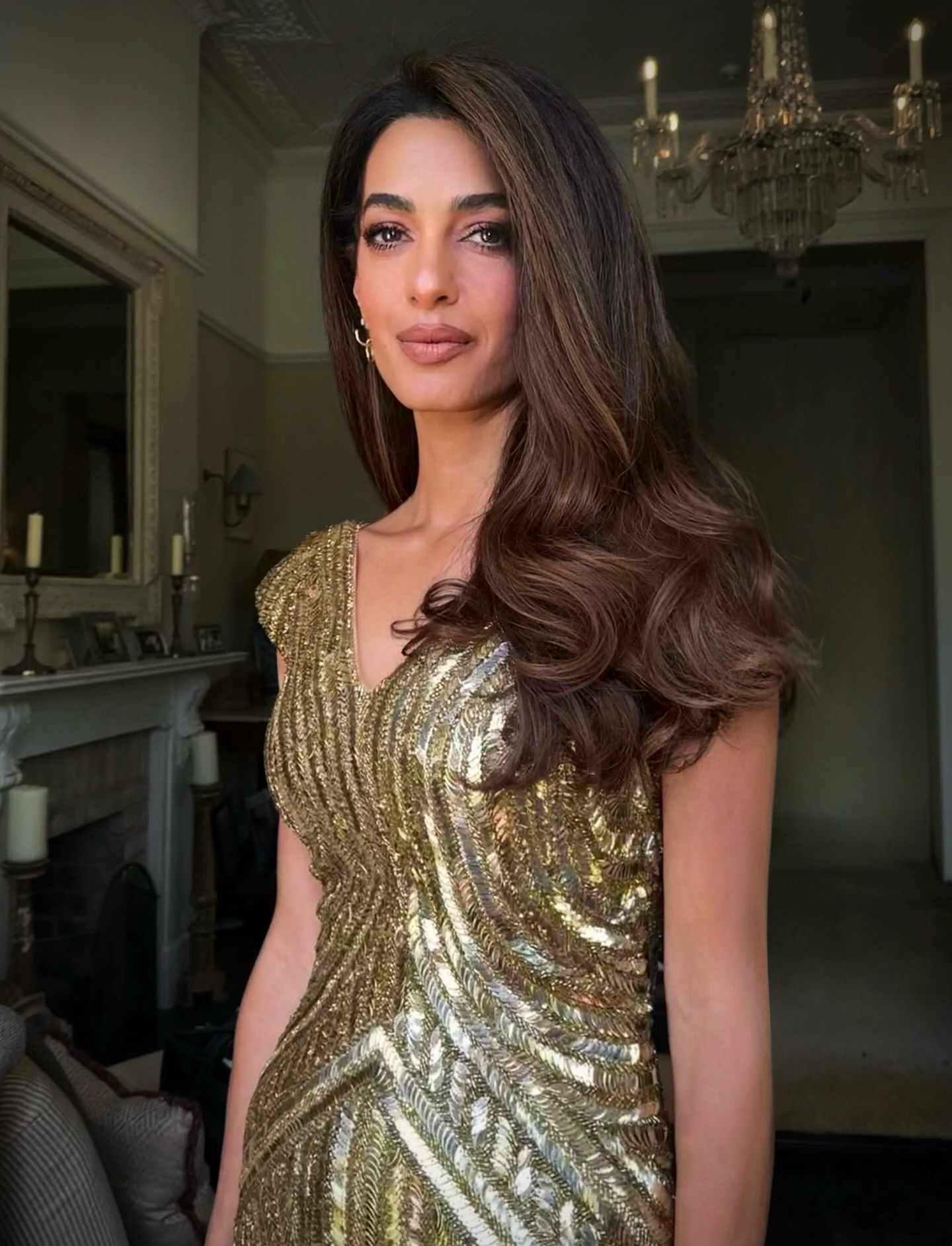 Amal Clooney wearing a gold dress with deep brunette hair