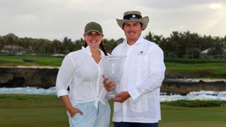 Joel Dahmen poses with the trophy and his wife Lona after putting in to win on the 18th green during the final round of the Corales Puntacana Resort & Club Championship on March 28, 2021 in Punta Cana.