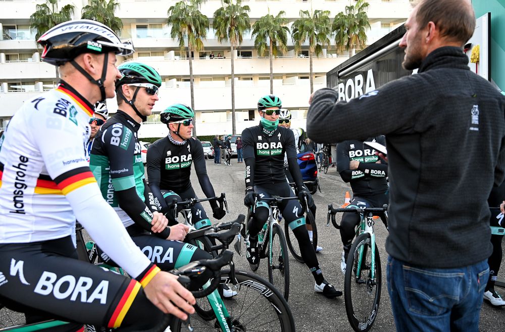 Bora-Hansgrohe riders gather near the team bus before the start of a ride