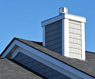 A chimney poking out of a tiled roof