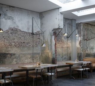 Exposed and damaged brick walls provide a contract to the clean bar and restaurant