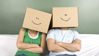 guy and girl with cardboard boxes over their heads with painted smiley faces