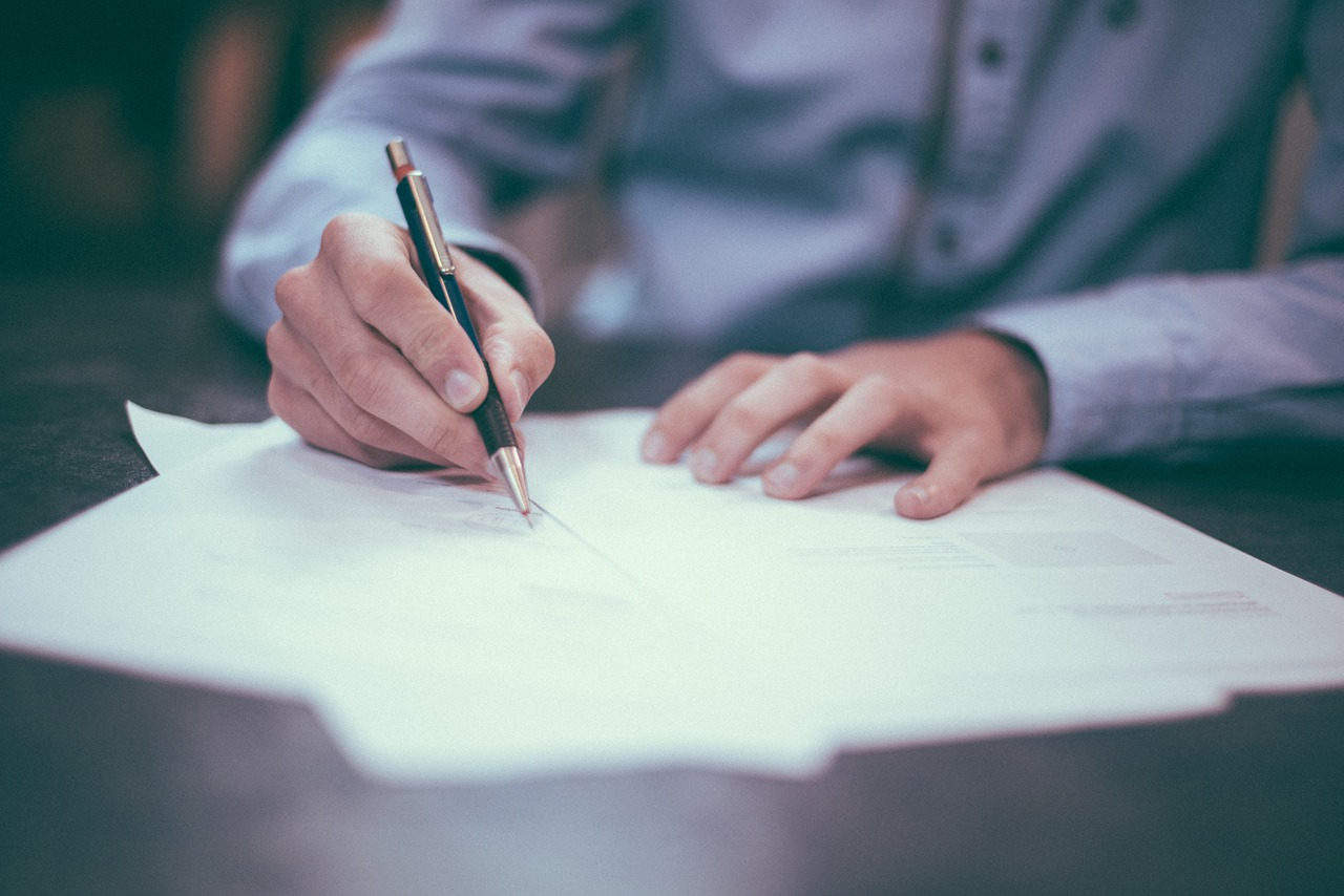 Close up of man writing with a pen.