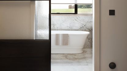 Bathroom with black sliding door and marble-effect flooring