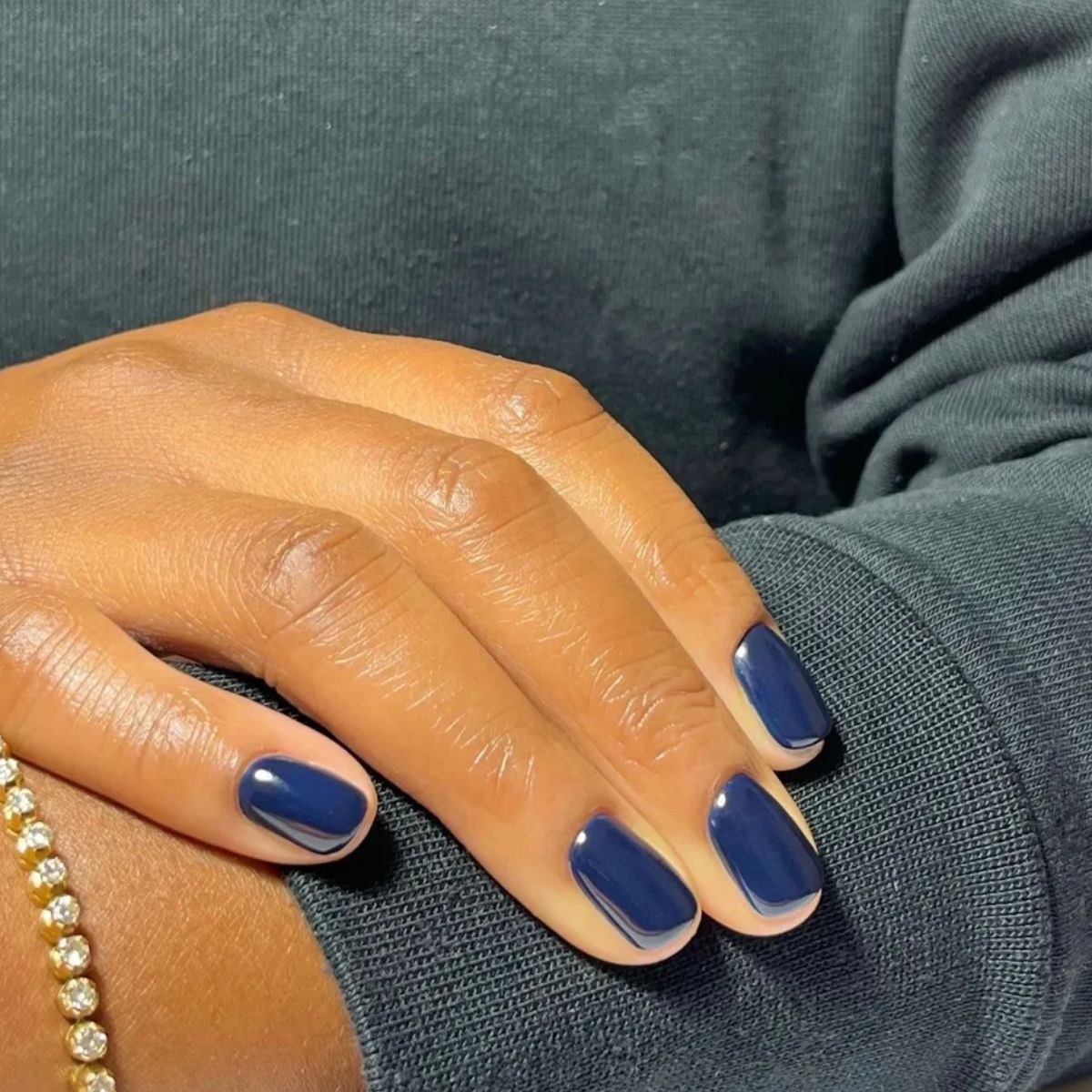 A close-up shot of a midnight blue manicure
