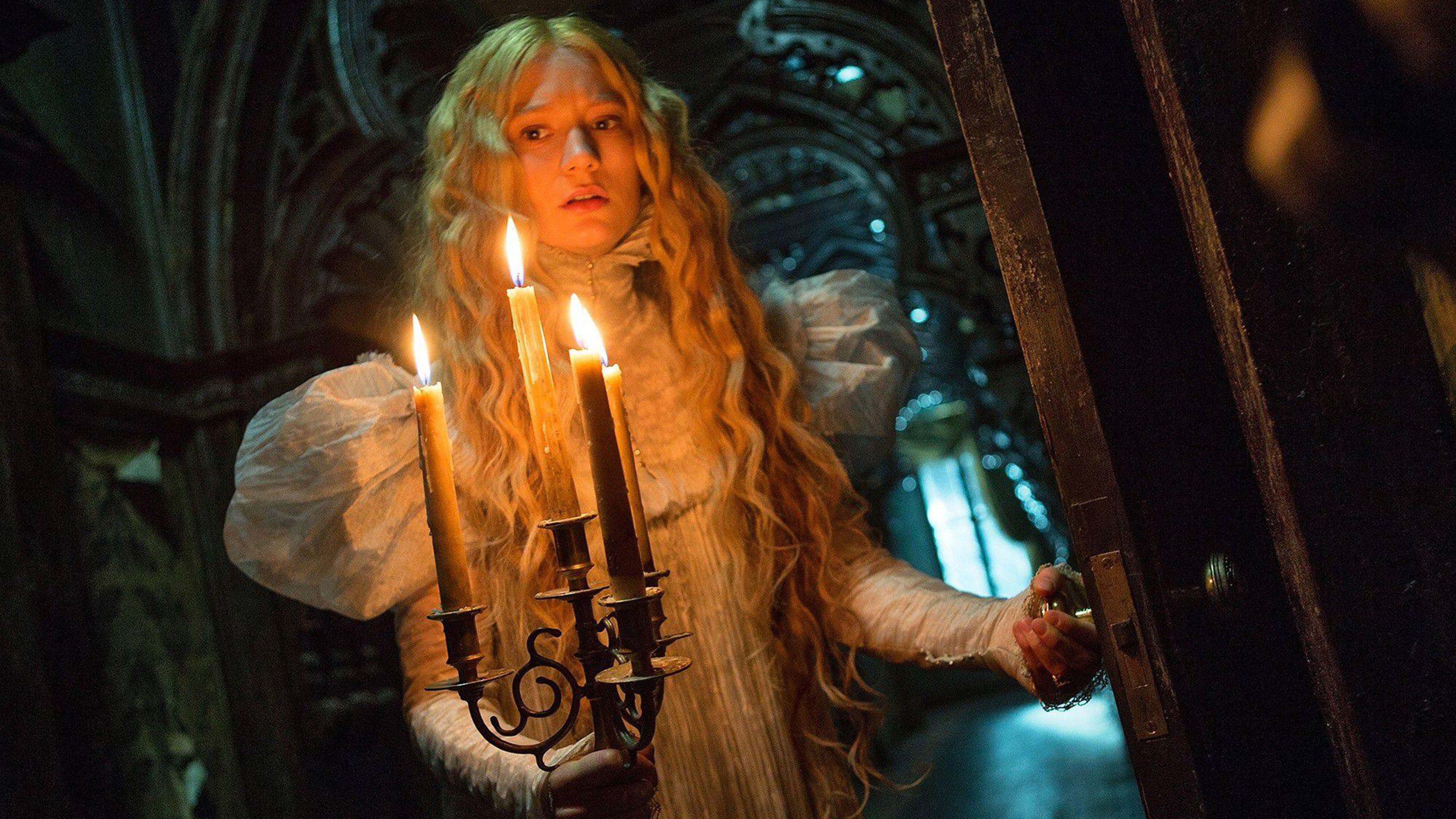 Edith (Mia Wasikowska) holding a candelabra in a scene from &quot;Crimson Peak&quot;